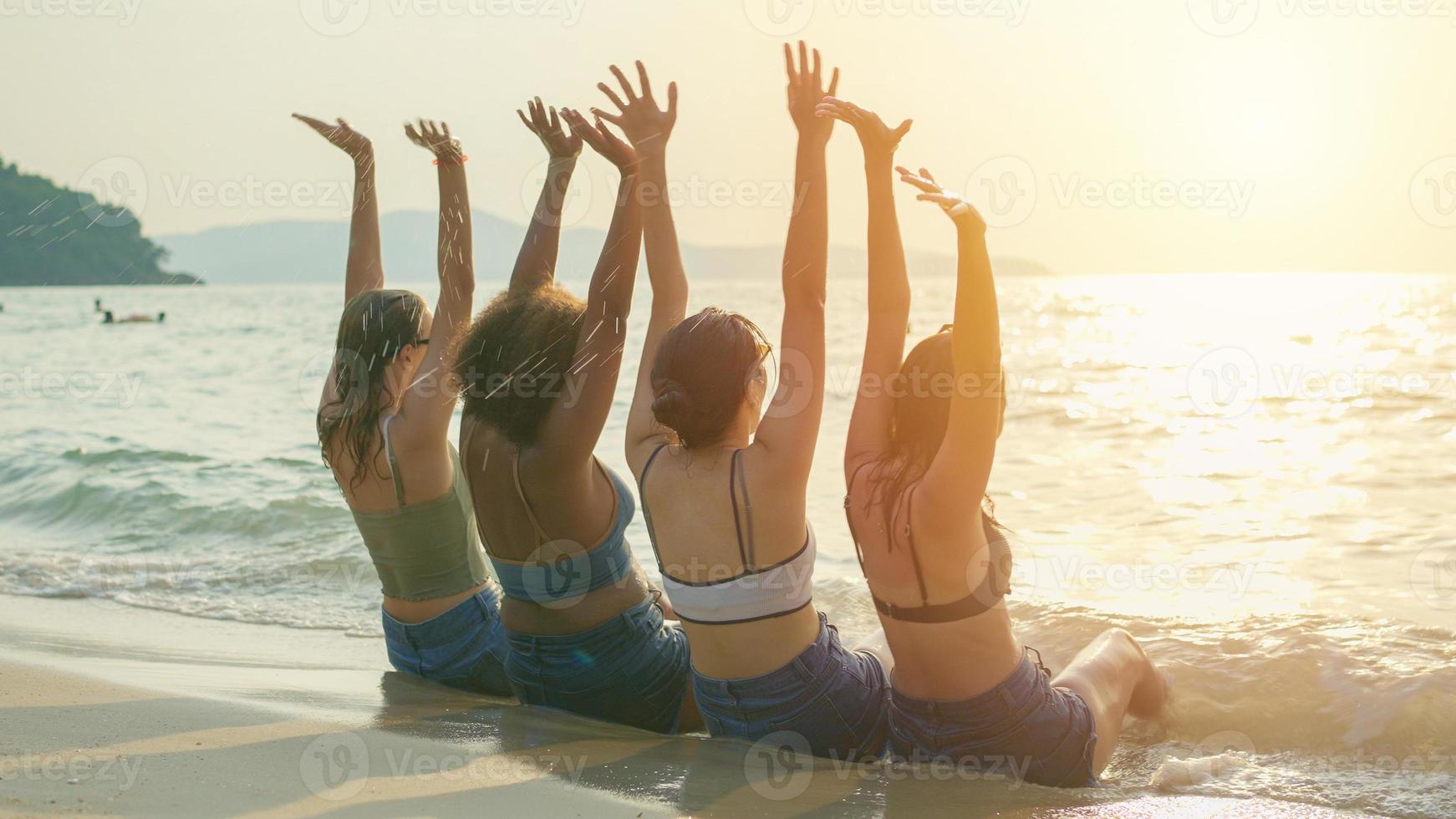 A group of teenage girls run and play at the beach for their summer vacation and they smile and enjoy their vacation. photo