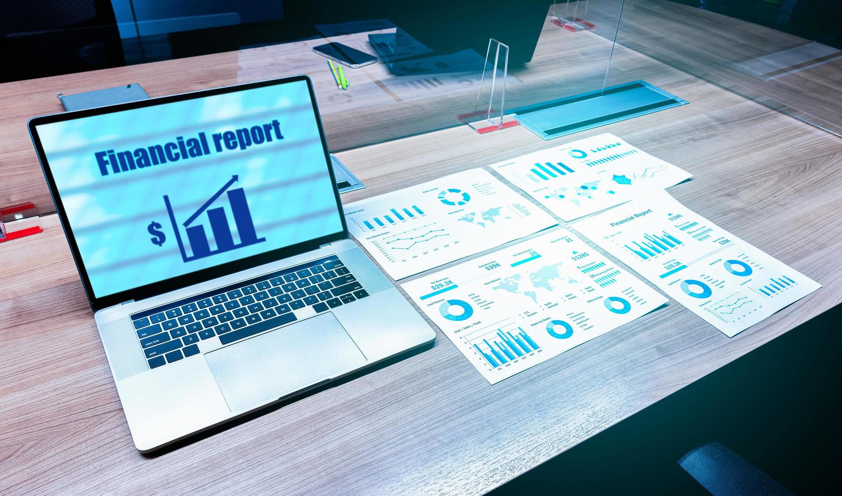 Financial report presentation on display laptop and paperwork on table in meeting room photo