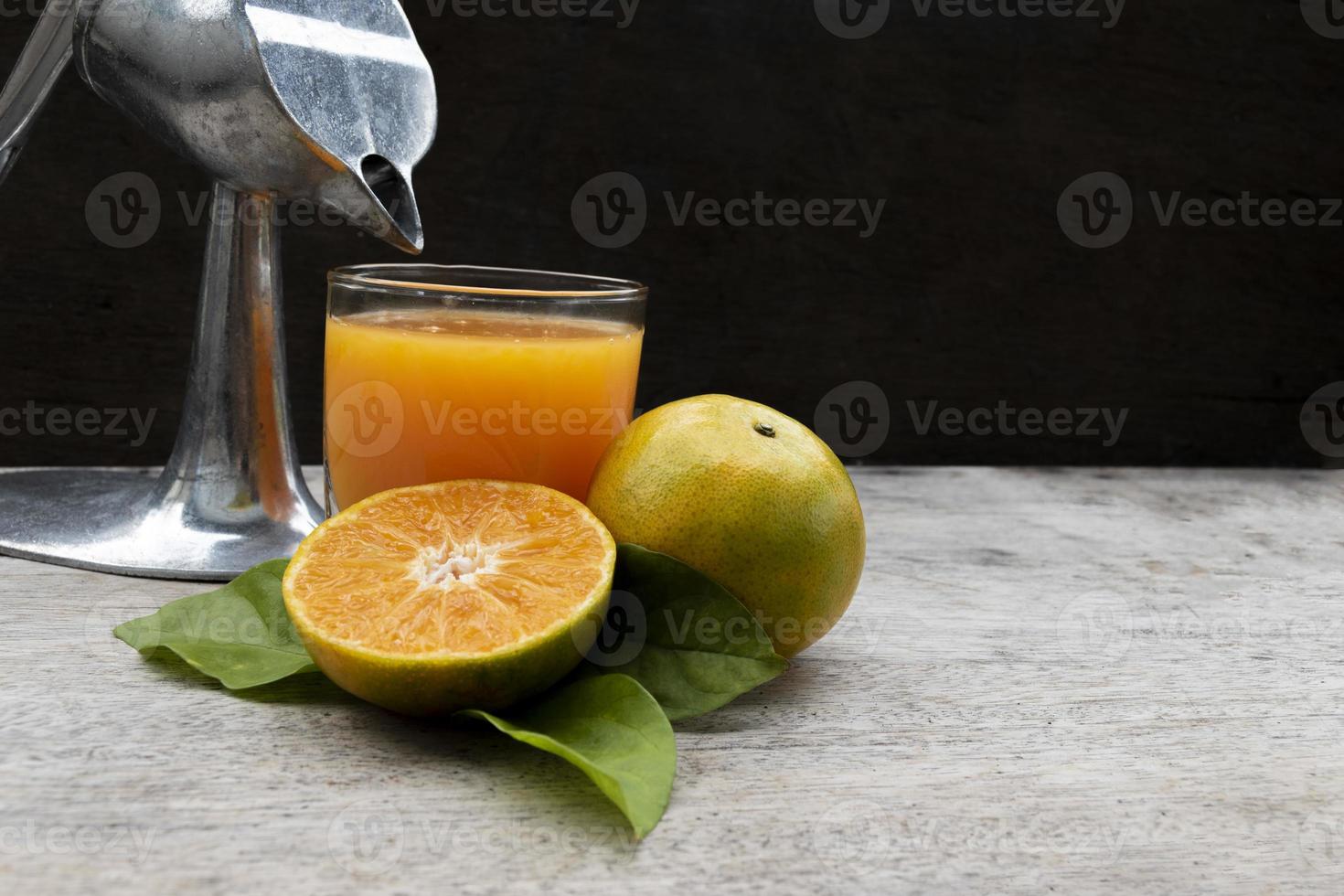 Orange juice in glass and fresh citrus around with Juicer hand press ...