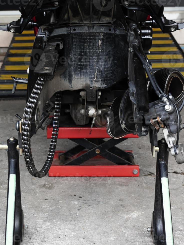 Back view motorcycle up to stand to remove wheel to change tire photo