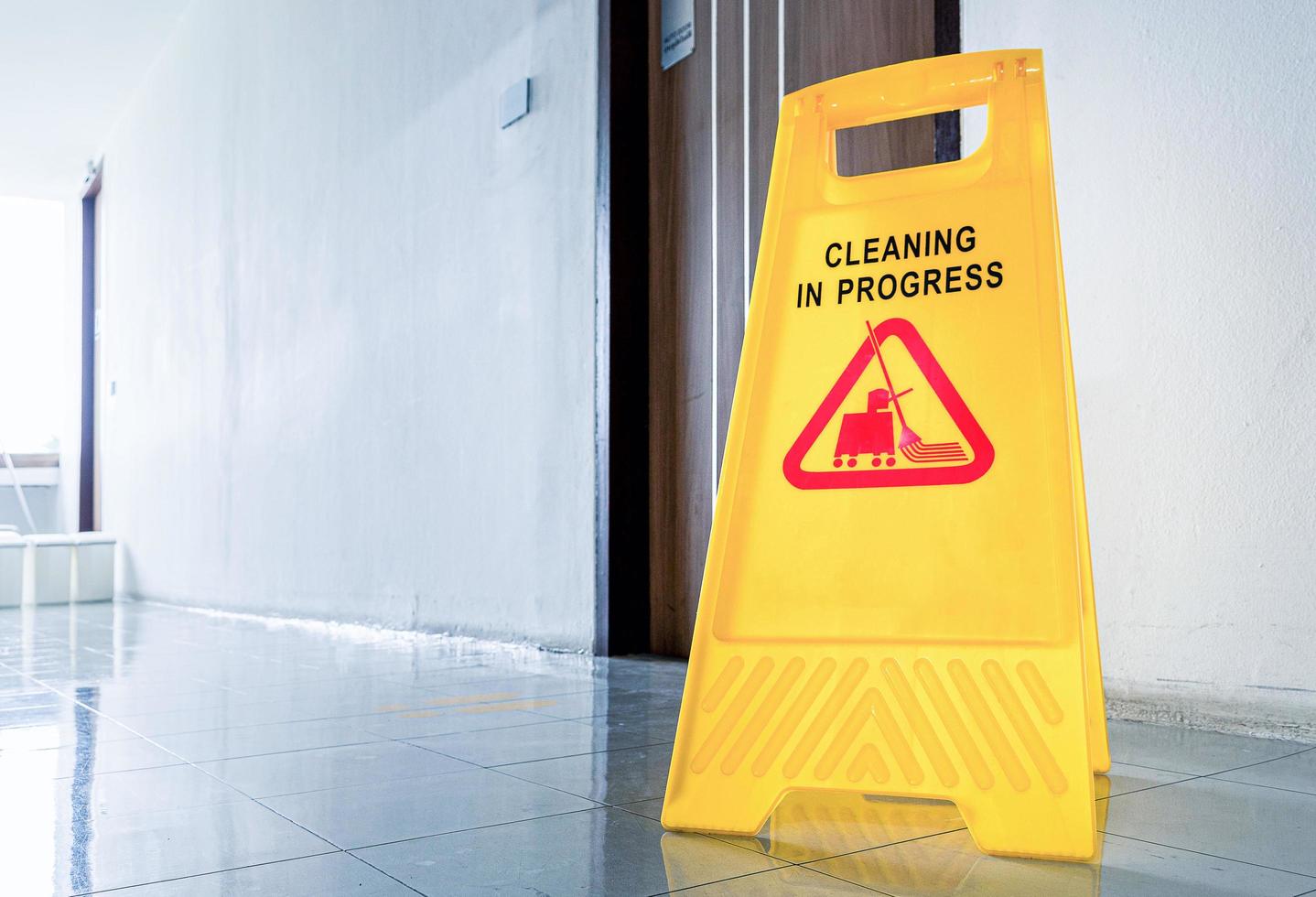 Close up yellow warning sign with message Cleaning in progress photo