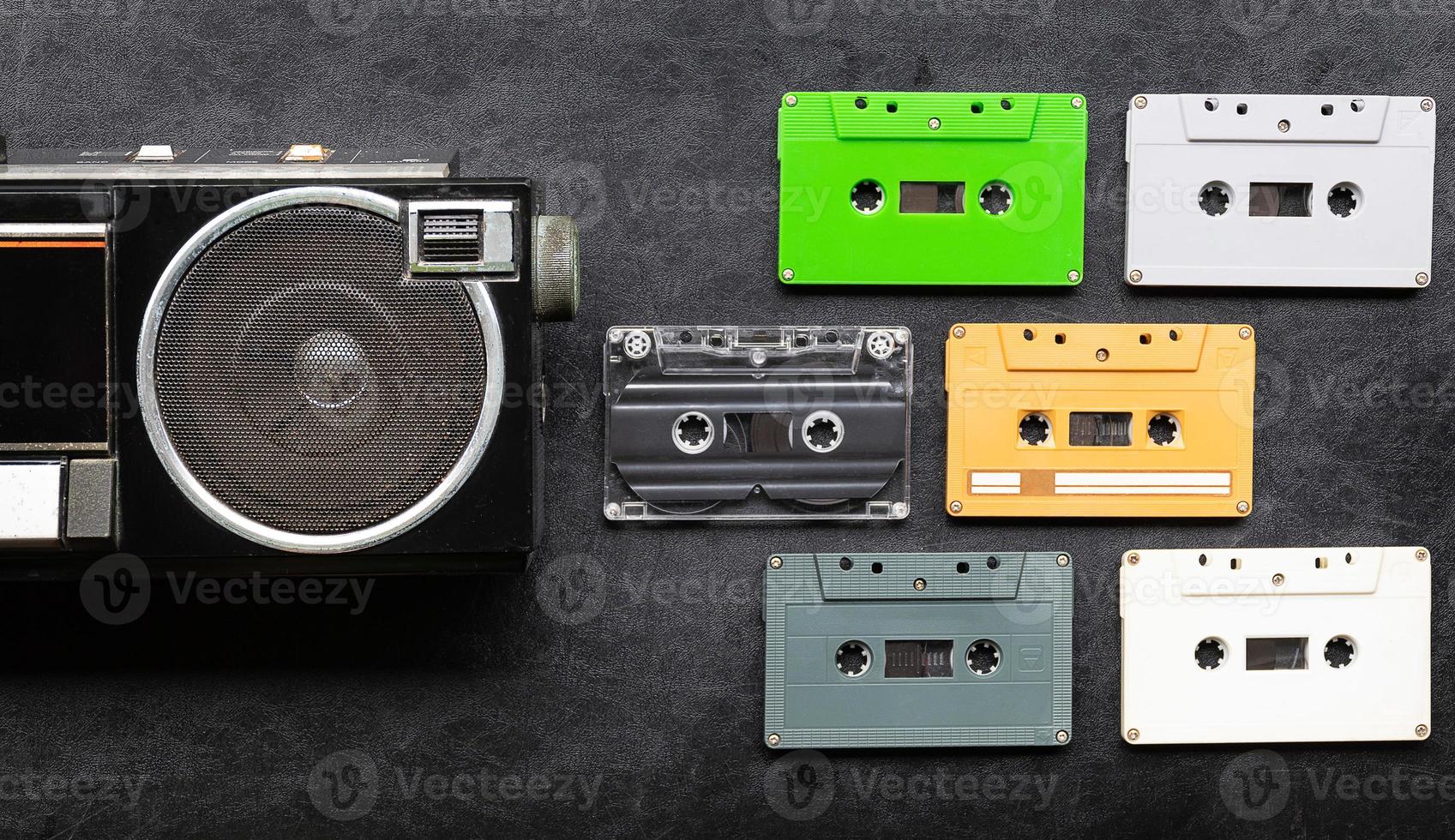 Top view half retro radio and colorful cassette tape on black floor with copy space photo