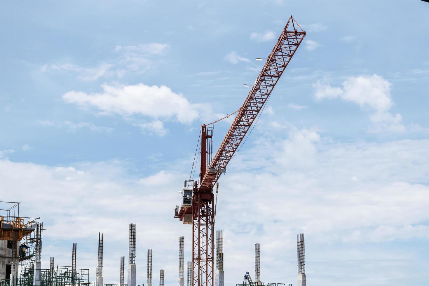 Tower construction crane in building construction site with blue sky background photo