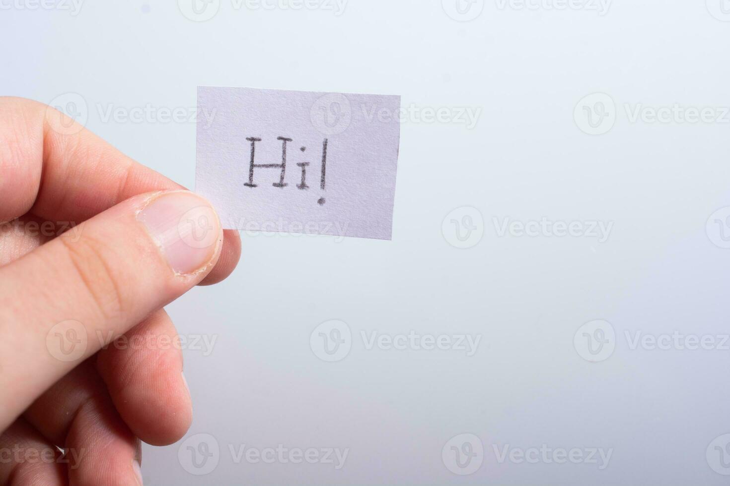 mano que sostiene el papel de carta con la redacción de hola en blanco foto