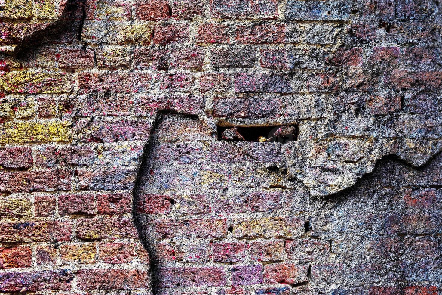 Detailed close up view on very old and weathered brick walls with cracks photo