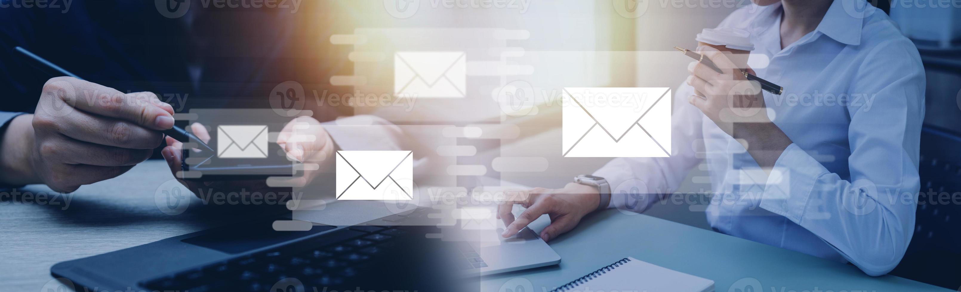 Businessman hands using Laptop typing on keyboard and surfing the internet on office table with email icon, email marketing concept, send e-mail or newsletter, online working internet network. photo