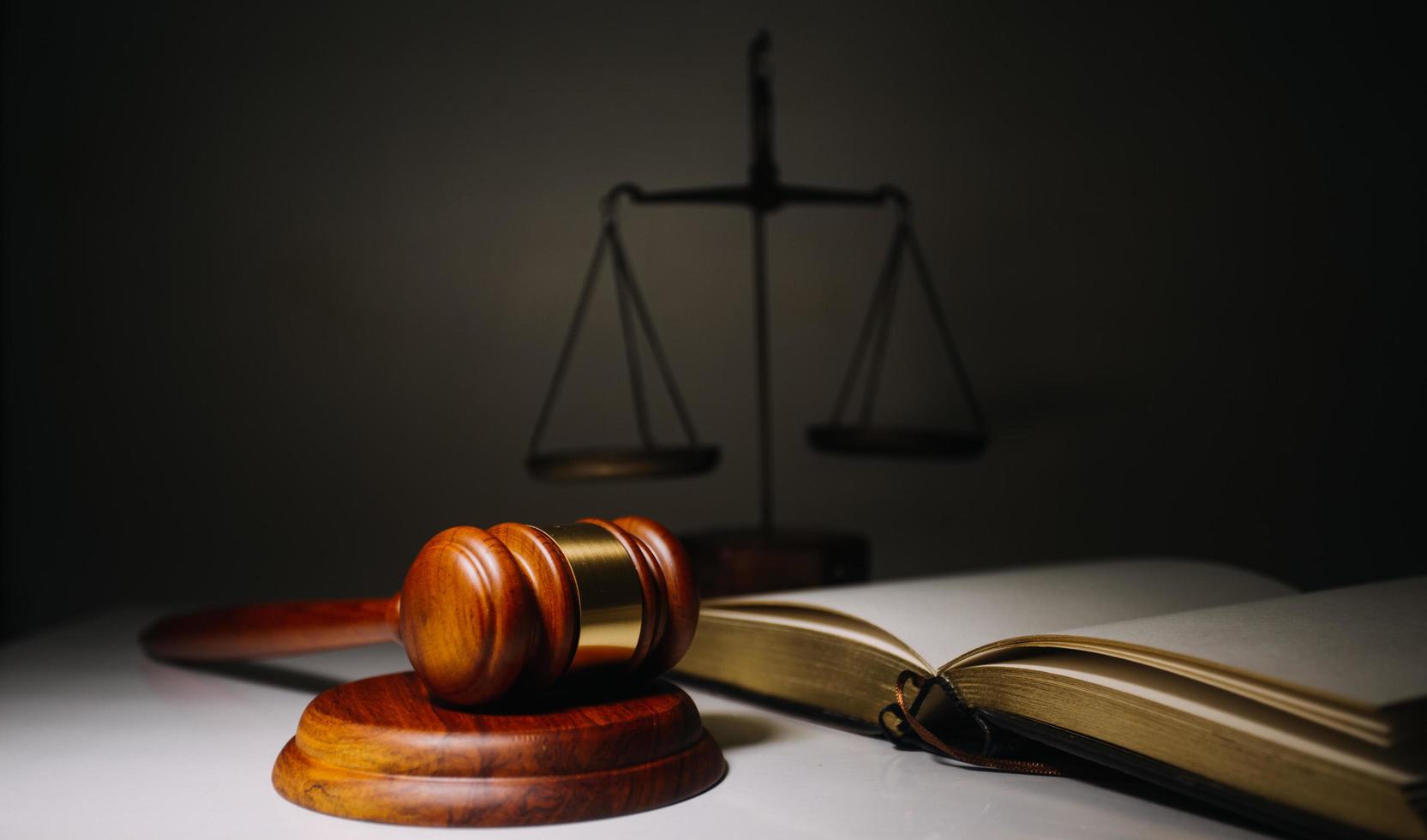 Business and lawyers discussing contract papers with brass scale on desk in office. Law, legal services, advice, justice and law concept photo