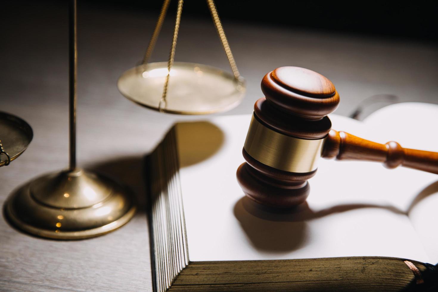 Justice and law concept.Male judge in a courtroom with the gavel, working with, computer and docking keyboard, eyeglasses, on table in morning light photo