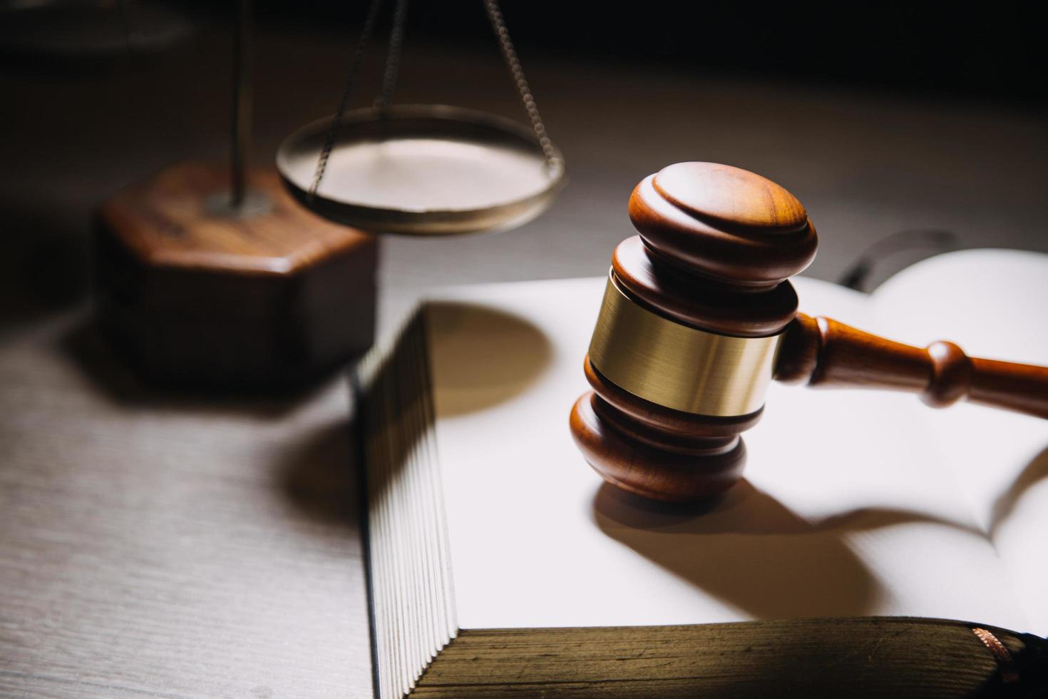Justice and law concept.Male judge in a courtroom with the gavel, working with, computer and docking keyboard, eyeglasses, on table in morning light photo