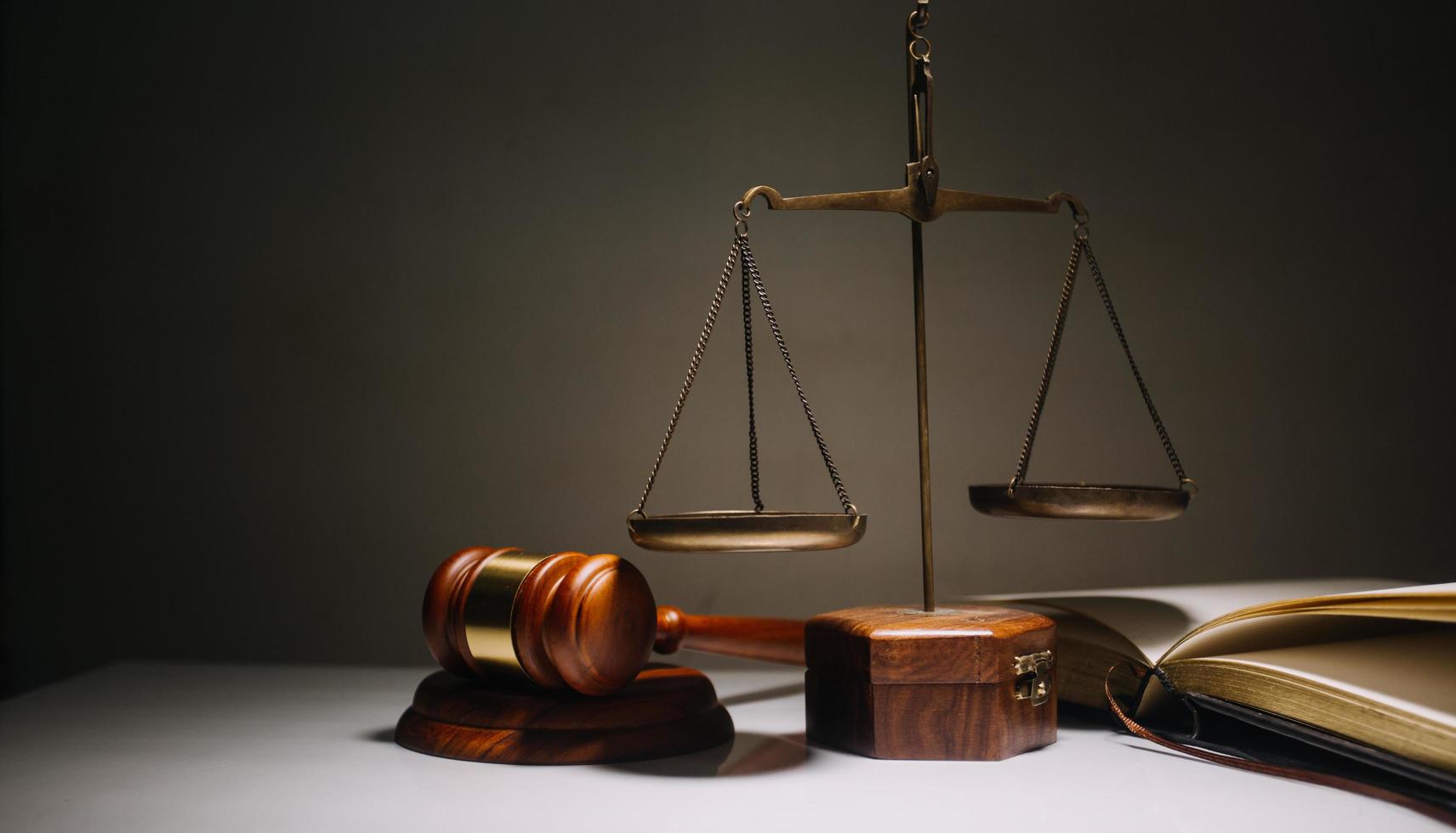 Business and lawyers discussing contract papers with brass scale on desk in office. Law, legal services, advice, justice and law concept photo