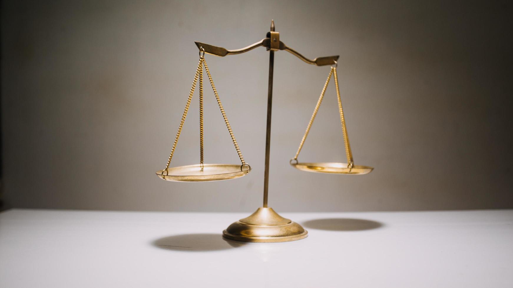 Business and lawyers discussing contract papers with brass scale on desk in office. Law, legal services, advice, justice and law concept photo