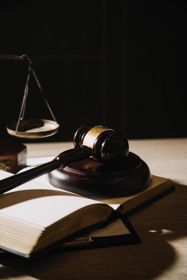 Justice and law concept.Male judge in a courtroom with the gavel, working with, computer and docking keyboard, eyeglasses, on table in morning light photo