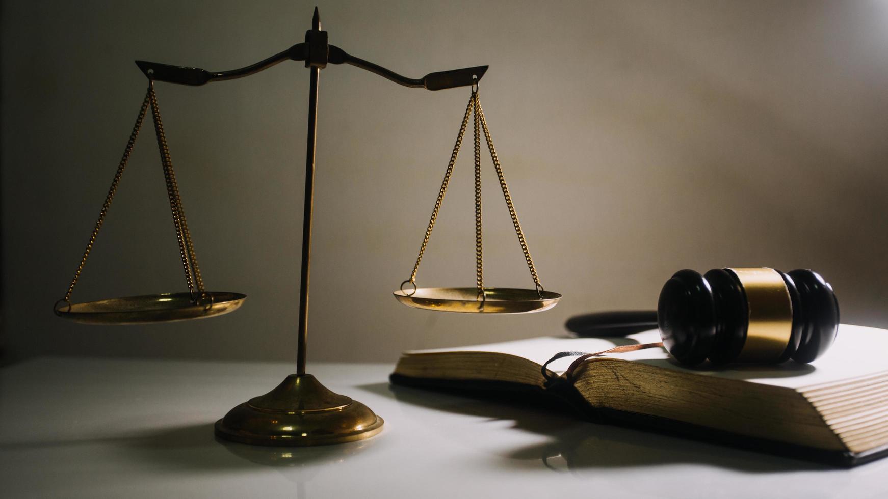 Business and lawyers discussing contract papers with brass scale on desk in office. Law, legal services, advice, justice and law concept photo