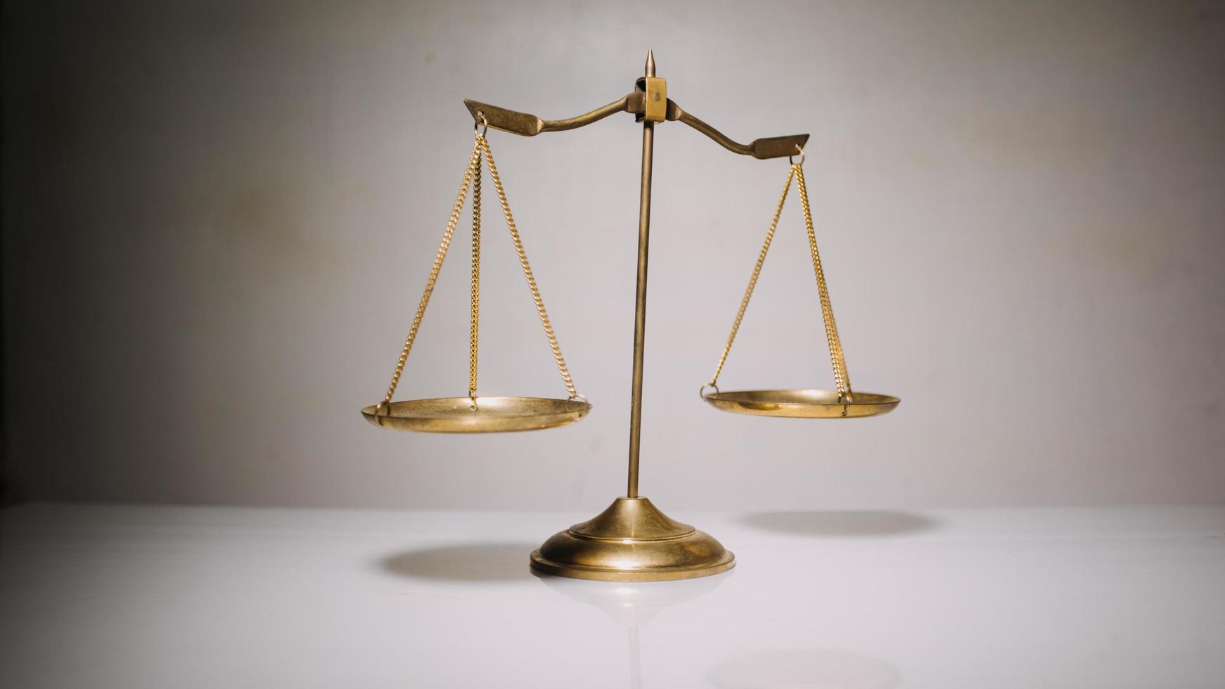 Business and lawyers discussing contract papers with brass scale on desk in office. Law, legal services, advice, justice and law concept photo