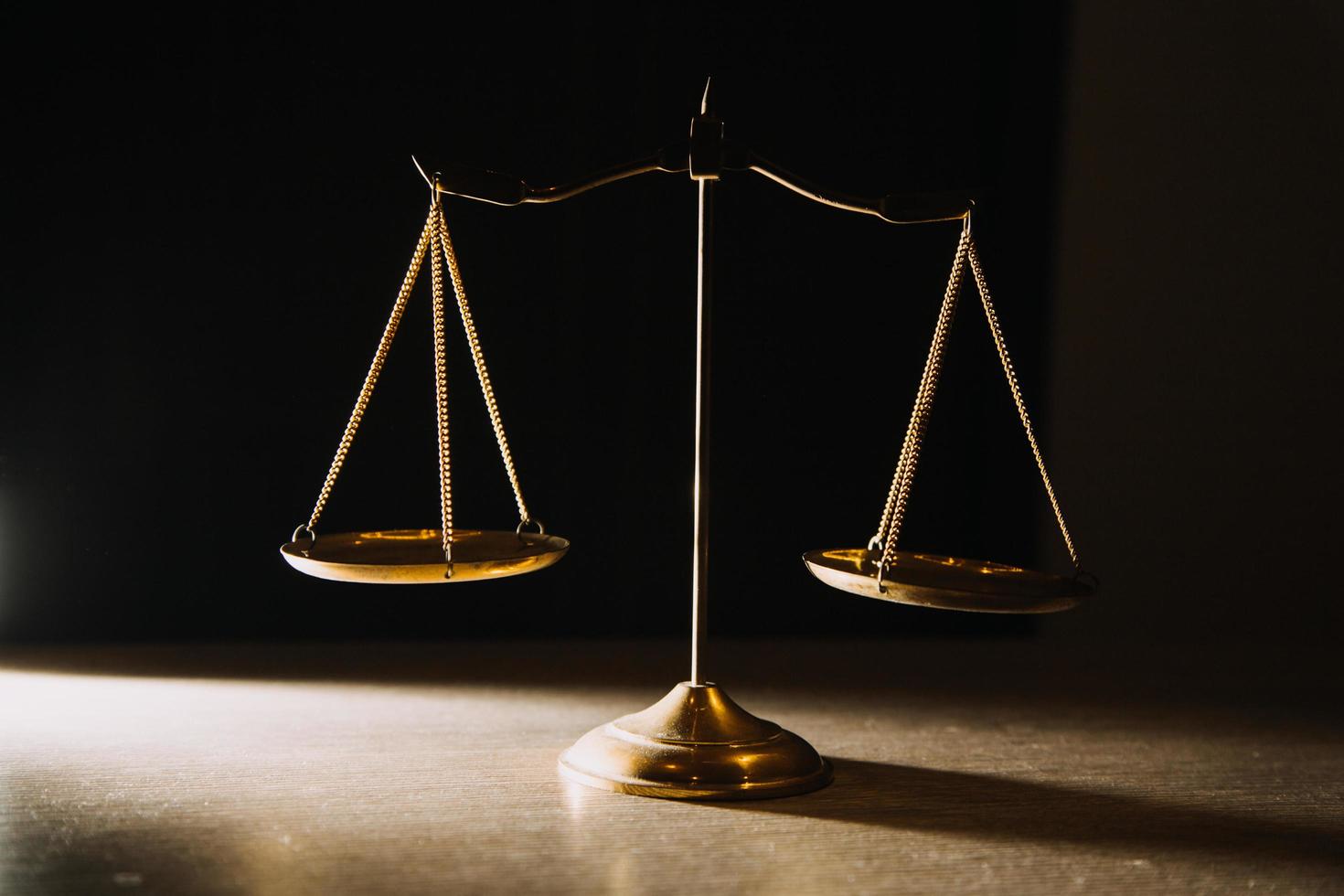 Business and lawyers discussing contract papers with brass scale on desk in office. Law, legal services, advice, justice and law concept picture with film grain effect photo