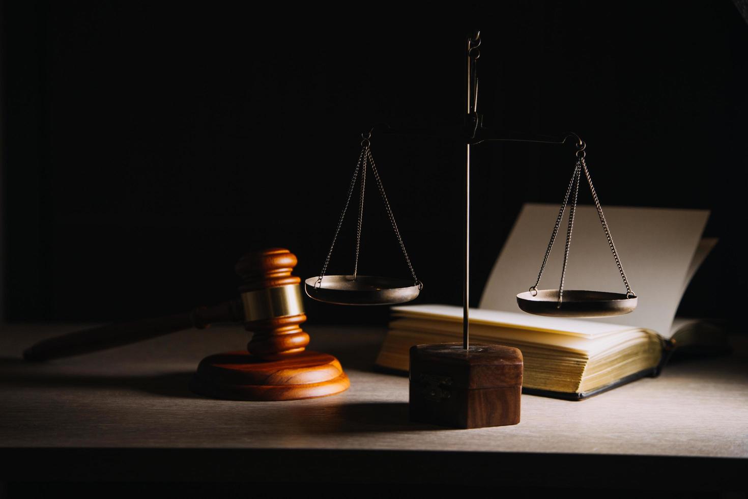 Justice and law concept.Male judge in a courtroom with the gavel, working with, computer and docking keyboard, eyeglasses, on table in morning light photo