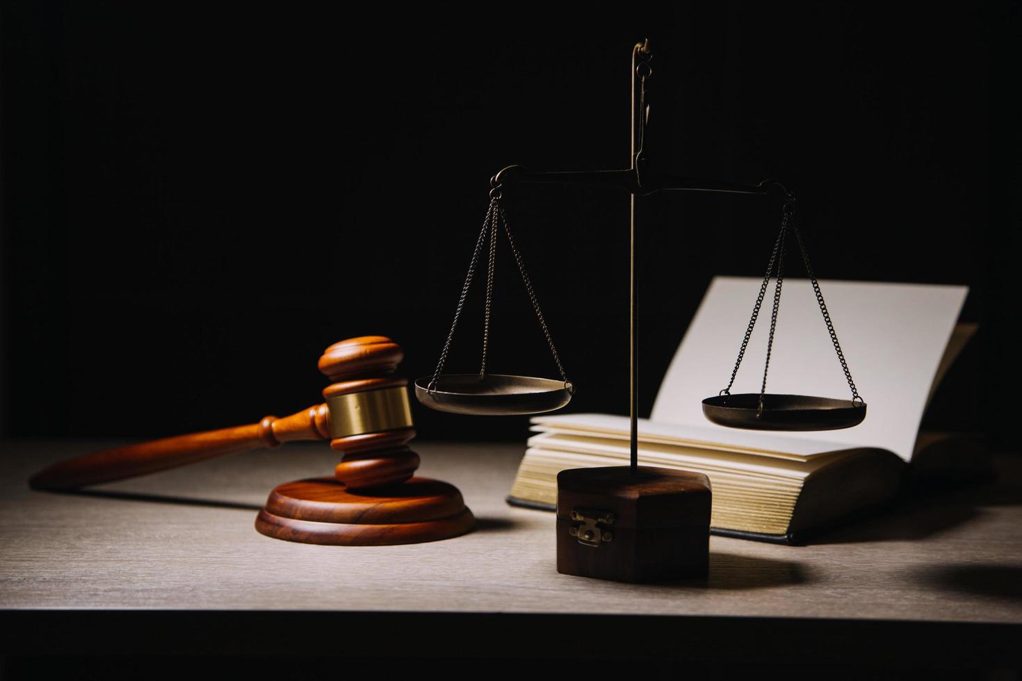 Business and lawyers discussing contract papers with brass scale on desk in office. Law, legal services, advice, justice and law concept picture with film grain effect photo