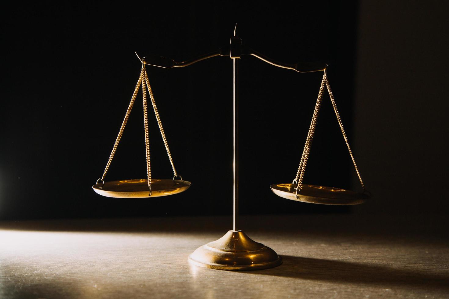 Business and lawyers discussing contract papers with brass scale on desk in office. Law, legal services, advice, justice and law concept picture with film grain effect photo