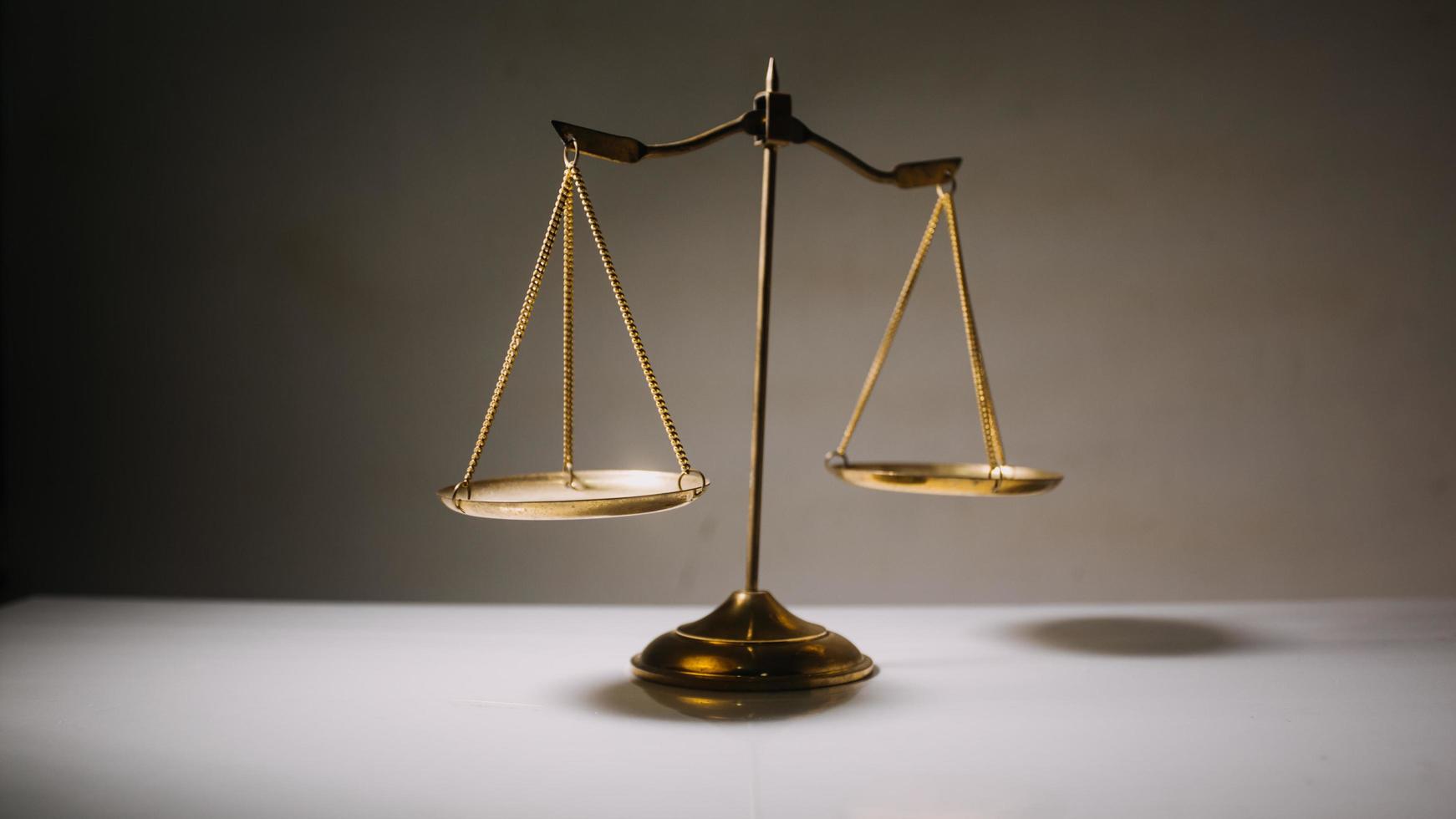 Business and lawyers discussing contract papers with brass scale on desk in office. Law, legal services, advice, justice and law concept photo