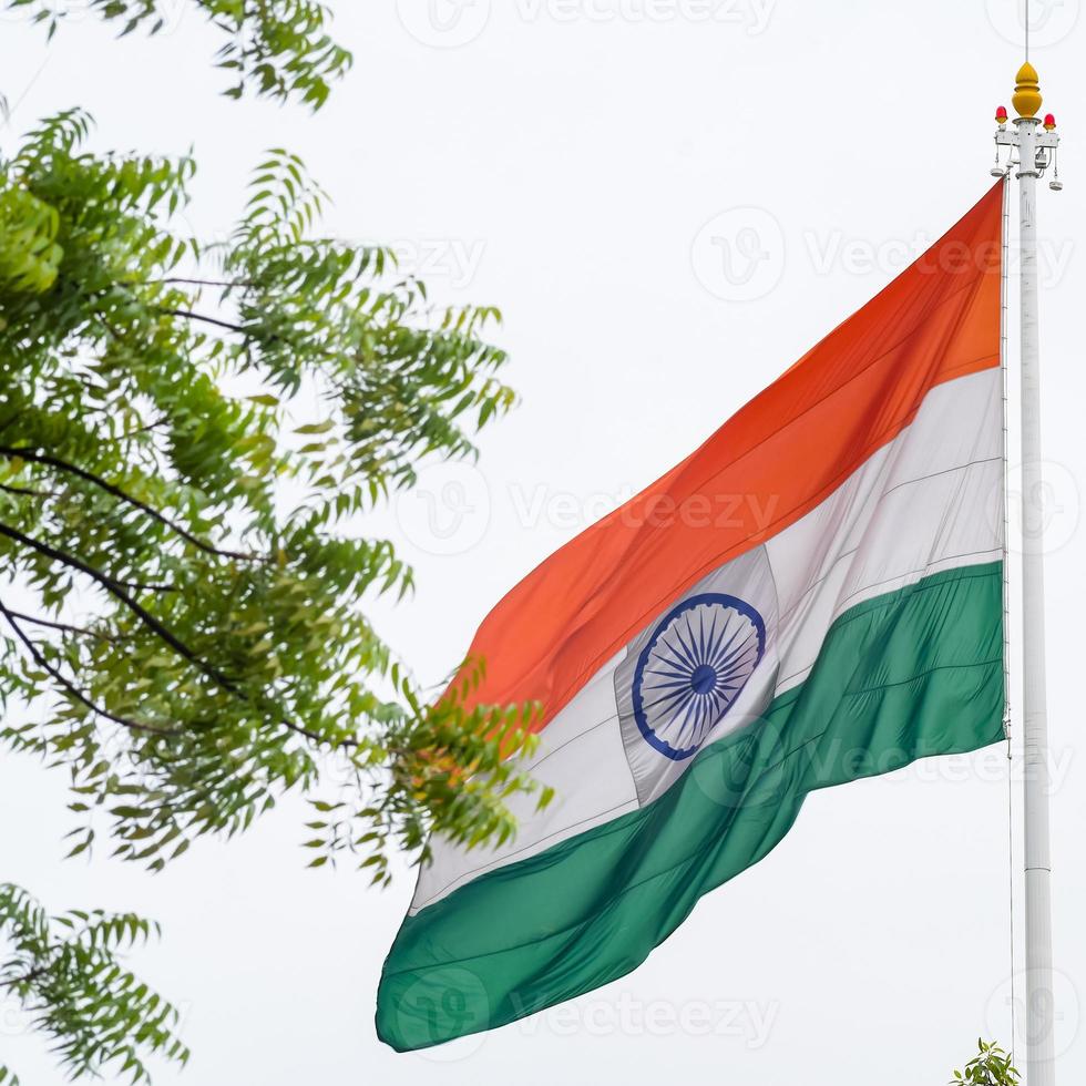 India flag flying high at Connaught Place with pride in blue sky, India flag fluttering, Indian Flag on Independence Day and Republic Day of India, tilt up shot, Waving Indian flag, Har Ghar Tiranga photo