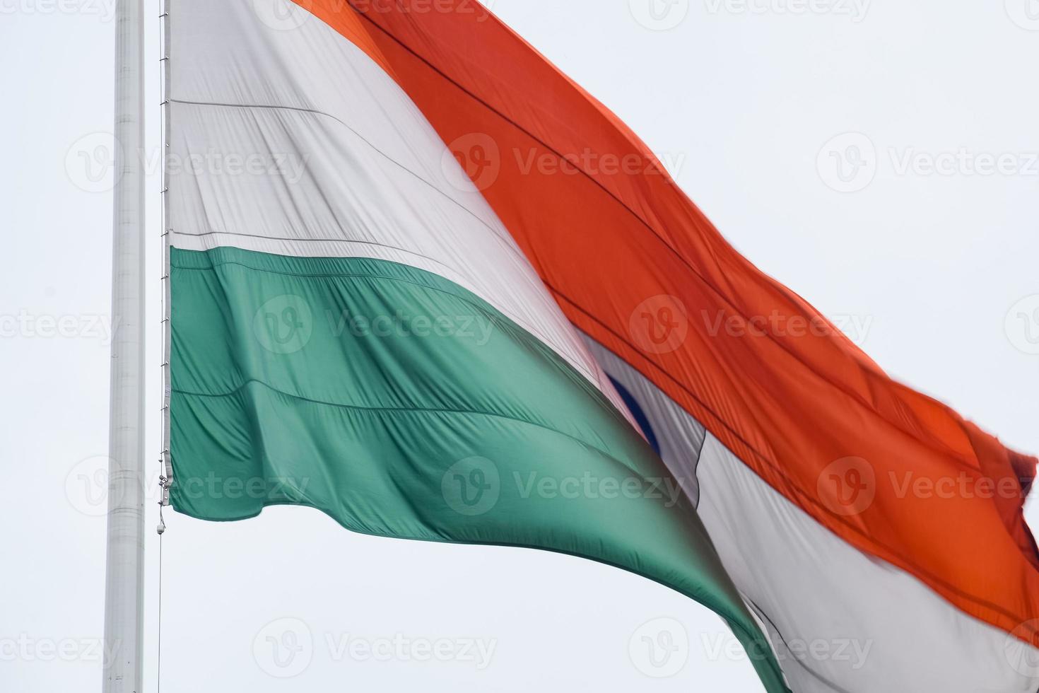 India flag flying high at Connaught Place with pride in blue sky, India flag fluttering, Indian Flag on Independence Day and Republic Day of India, tilt up shot, Waving Indian flag, Har Ghar Tiranga photo