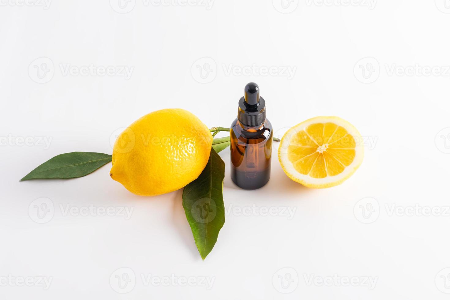 a cosmetic, a serum based on lemon essential oil on a white background with a ripe juicy lemon. natural care for problem skin of the face. photo
