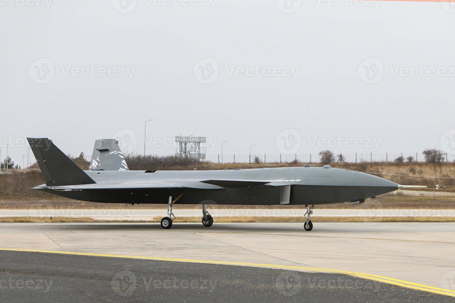 bayraktar kizilelma avión aéreo no tripulado aterrizando en el suelo. toma lateral del vehículo aéreo no tripulado bayraktar kizilelma calentando los motores para despegar. foto