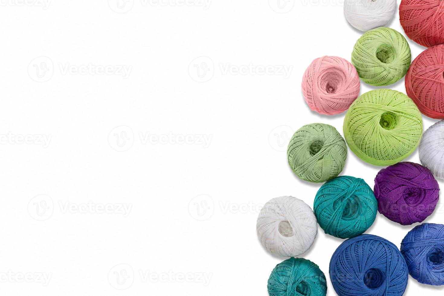 Multicolored balls and bobbins of woolen yarn, wooden thread sleeves on white isolated background. Needlework, handmade.  view from above. Isolated. Copy space photo