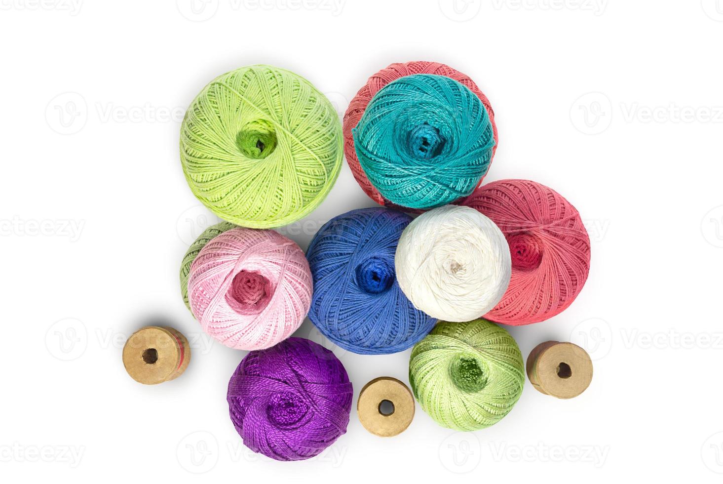 Multicolored balls and bobbins of woolen yarn, wooden thread sleeves on white isolated background. Needlework, handmade.  view from above. Isolated. Copy space photo