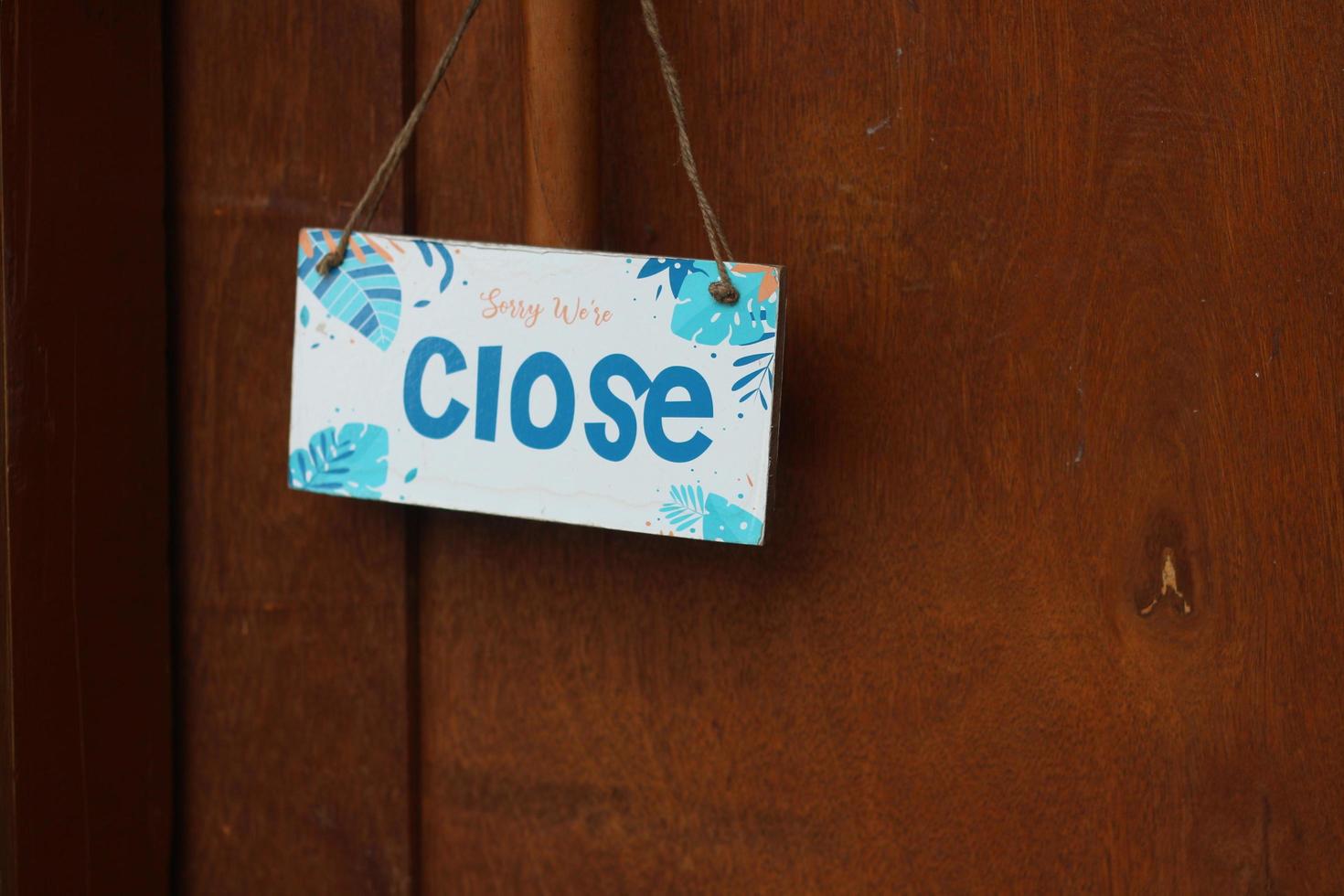 A wooden door with a closed shop sign. photo