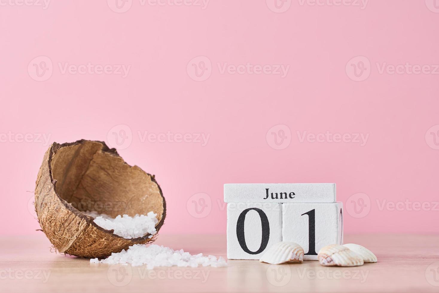 Wooden block calendar with date June 1 on pink background photo