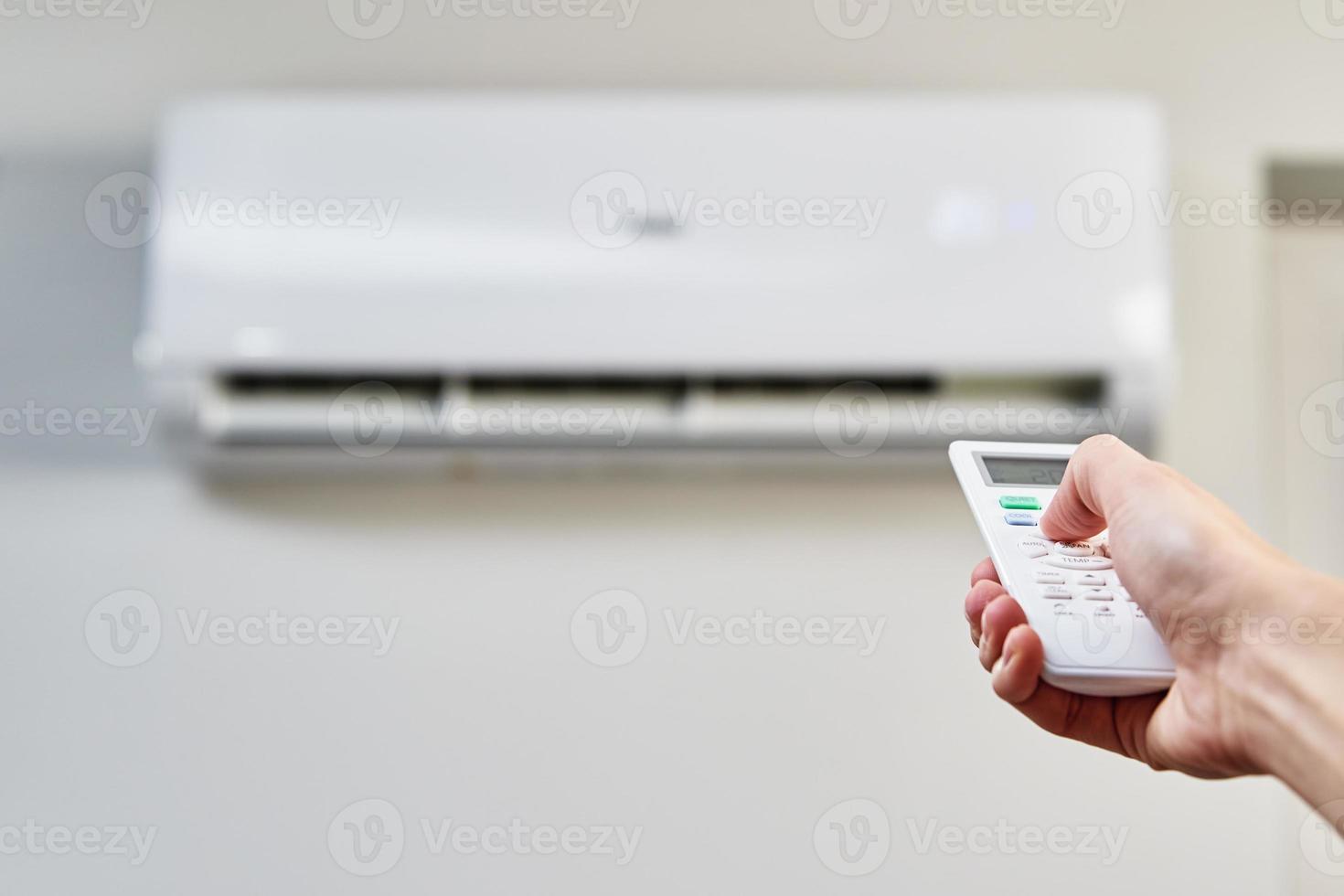 Hand adjusting temperature on air conditioner photo