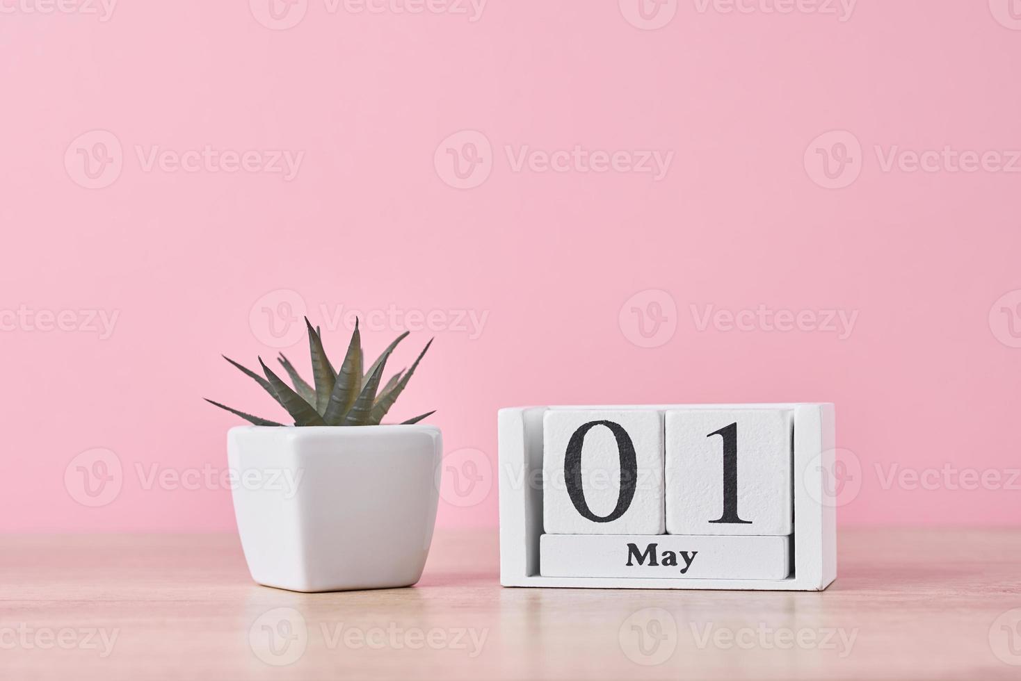 Wooden block calendar with date May 1 on pink background photo