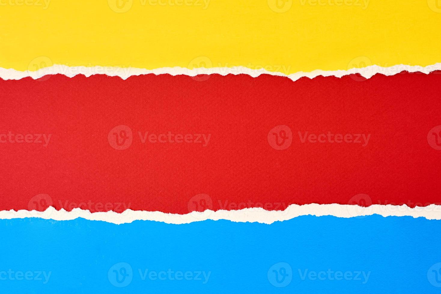 Torn ripped paper edge with a copy space, red, blue and yellow color background photo