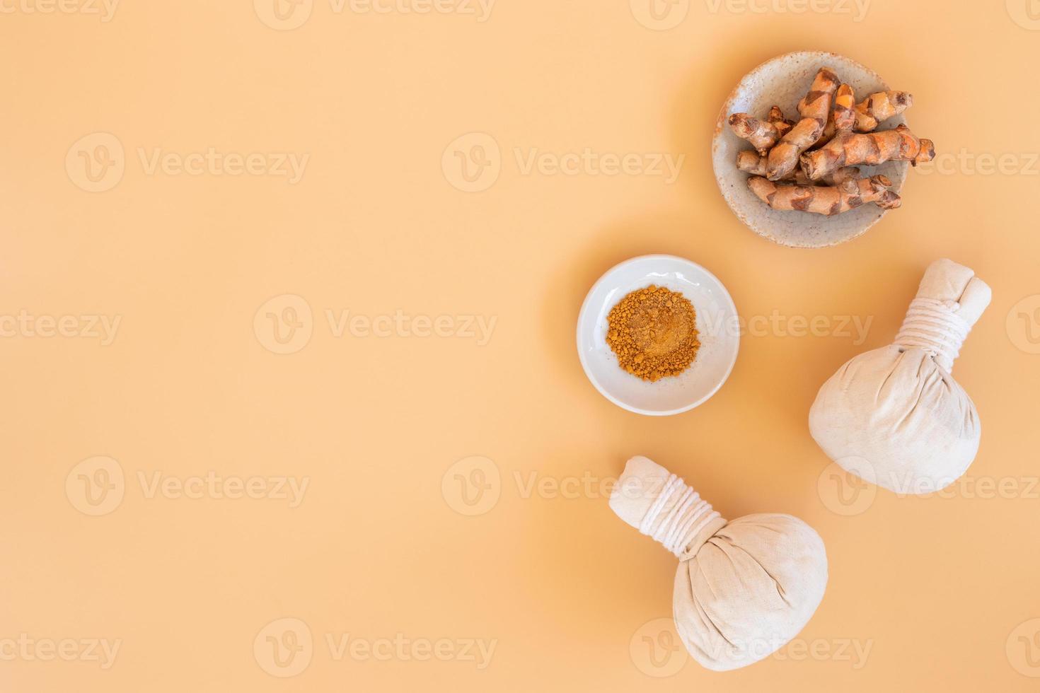 Top view of herbal compress ball with Thai herbal and turmeric on orange pastel background. Spa background concept. photo