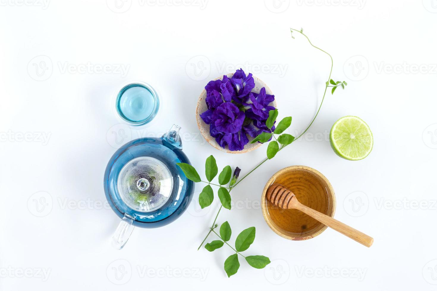 vista superior del té de flor de guisante de mariposa con limones sobre fondo blanco. concepto de bebida saludable. foto