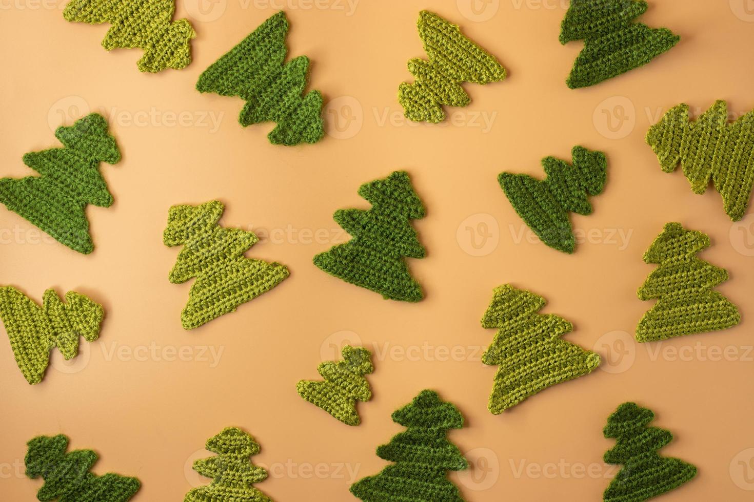 Handmade crochet christmas tree on orange pastel background. Merry Christmas and happy new year concept. photo