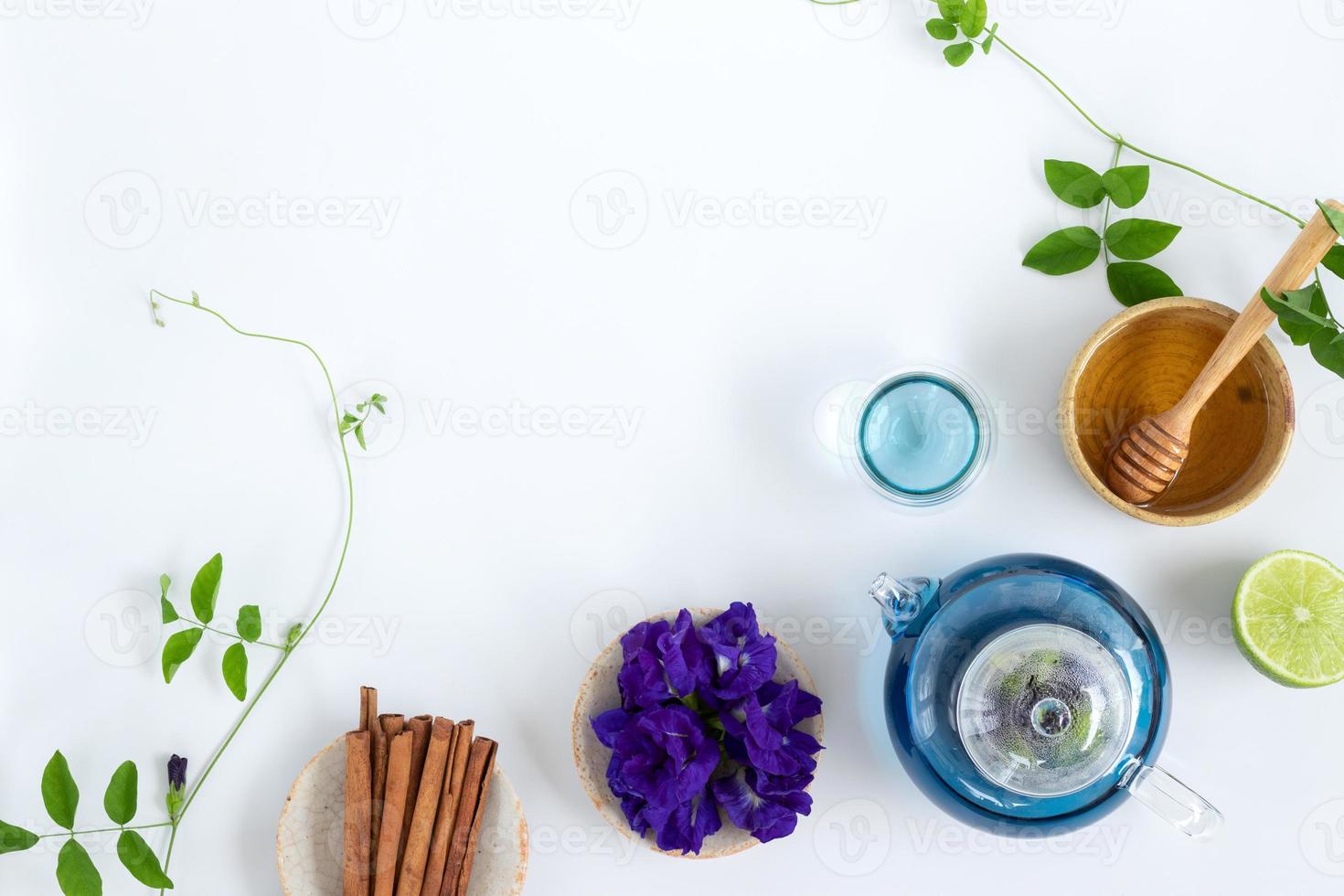 vista superior del té de flor de guisante de mariposa con limones sobre fondo blanco. concepto de bebida saludable. foto