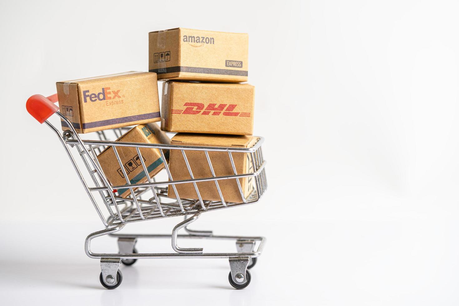 bangkok, tailandia - 26 de septiembre de 2022 carrito de compras con caja de embalaje dhl amazon express, negocio de inversión de intercambio en línea de importación y exportación. foto