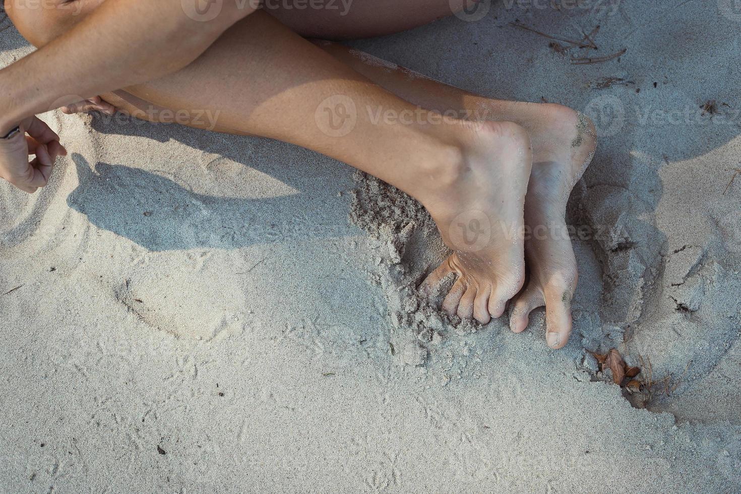 Close up barefeeted girl on beach concept photo