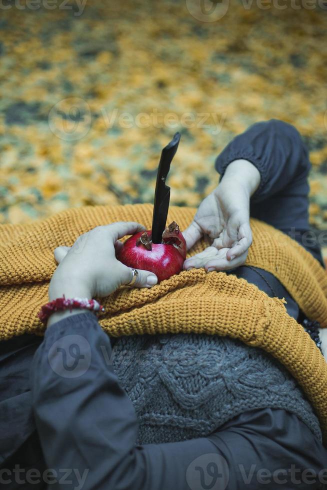 Close up woman holding pomegranate with knife concept photo