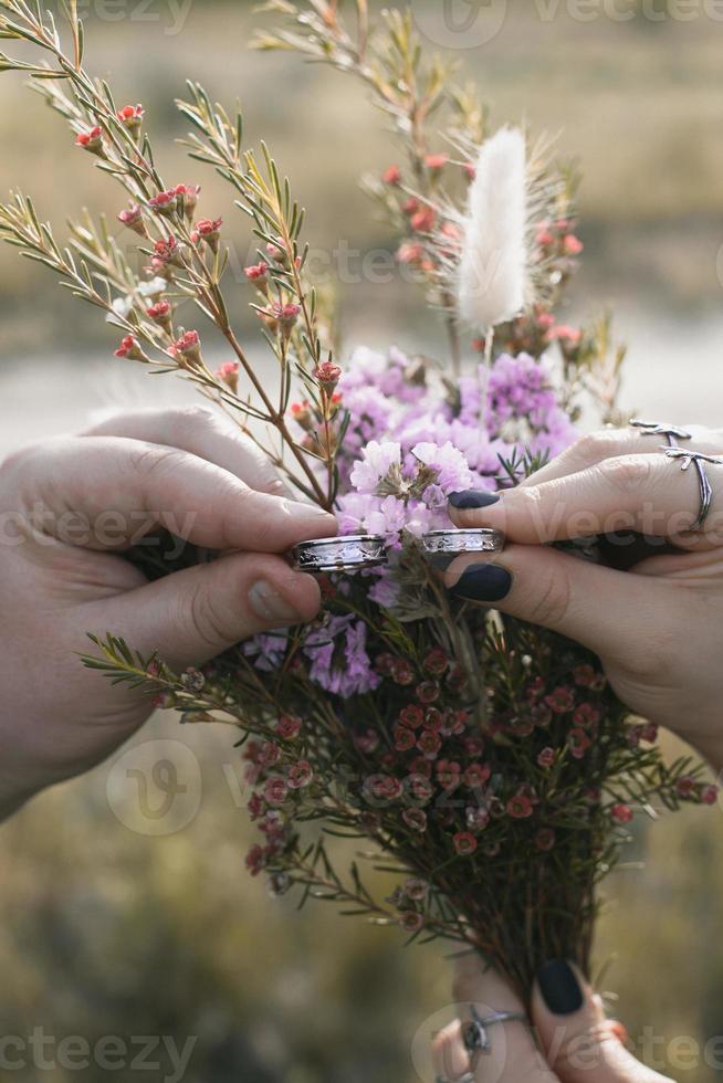 Close up wedding rings and flowers concept photo