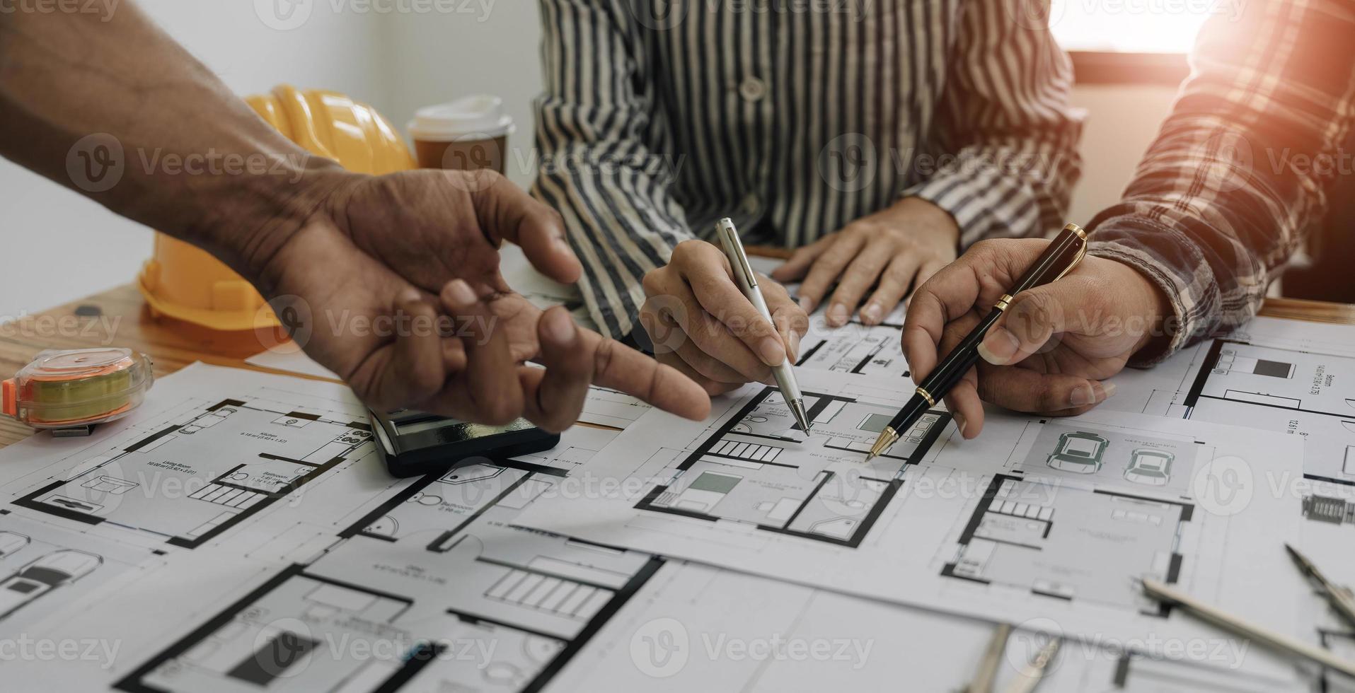 reunión de trabajo en equipo de ingenieros, trabajo de dibujo en la reunión de planos para el trabajo del proyecto con un socio en la construcción de modelos y herramientas de ingeniería en el concepto de sitio de trabajo, construcción y estructura. foto