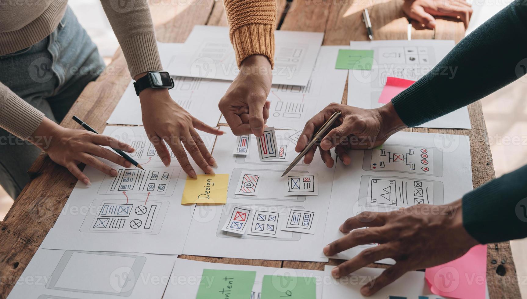 Close up ux developer and ui designer brainstorming about mobile app interface wireframe design on table with customer breif and color code at modern office.Creative digital development agency photo