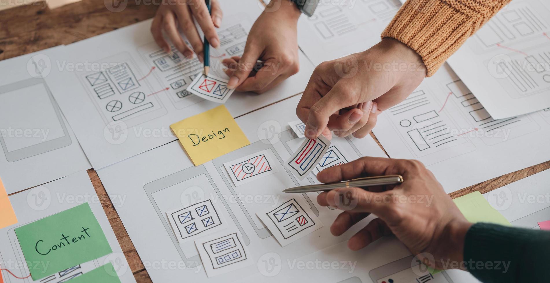 Close up ux developer and ui designer brainstorming about mobile app interface wireframe design on table with customer breif and color code at modern office.Creative digital development agency photo
