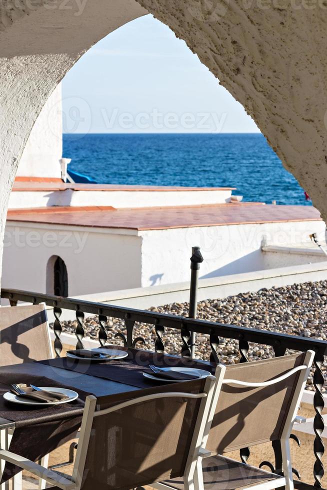 Restaurant table with plate and cutlery in front of a terrace with sea views. Holidays. Relax. photo