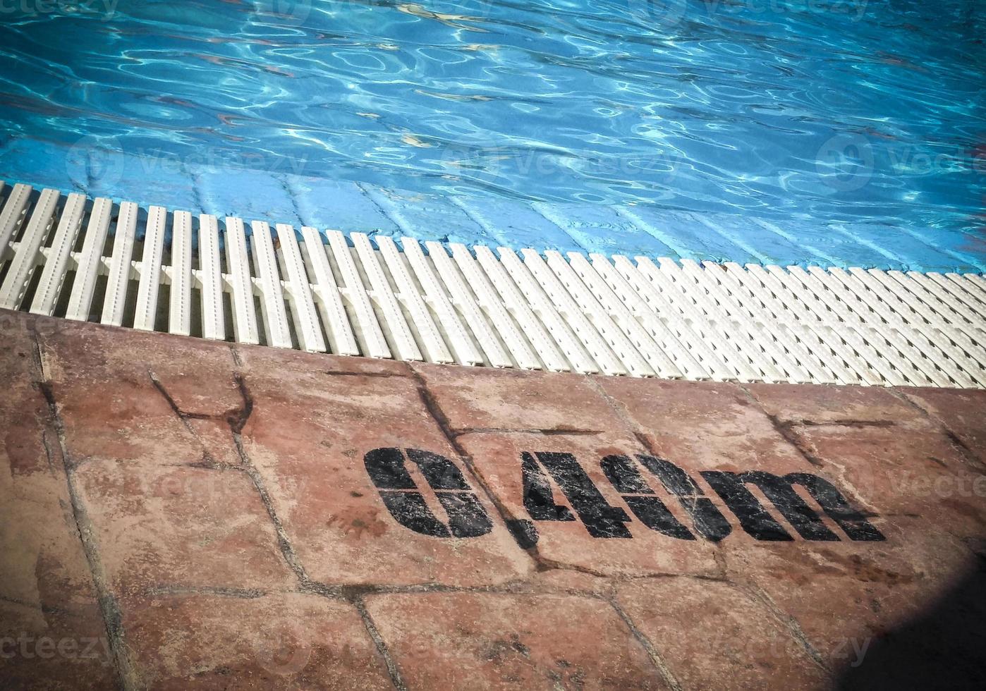 Edge of a swimming pool with depth markings photo