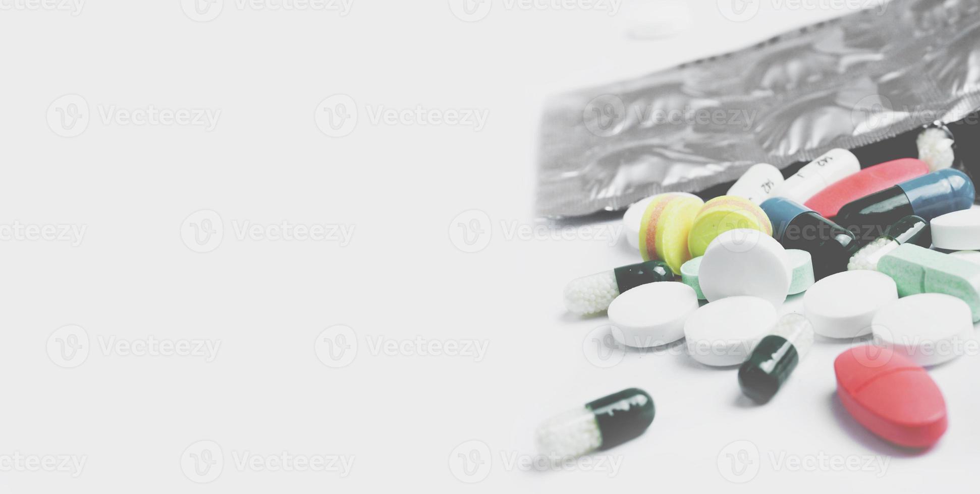 Multicolored pills and tablets on white background photo