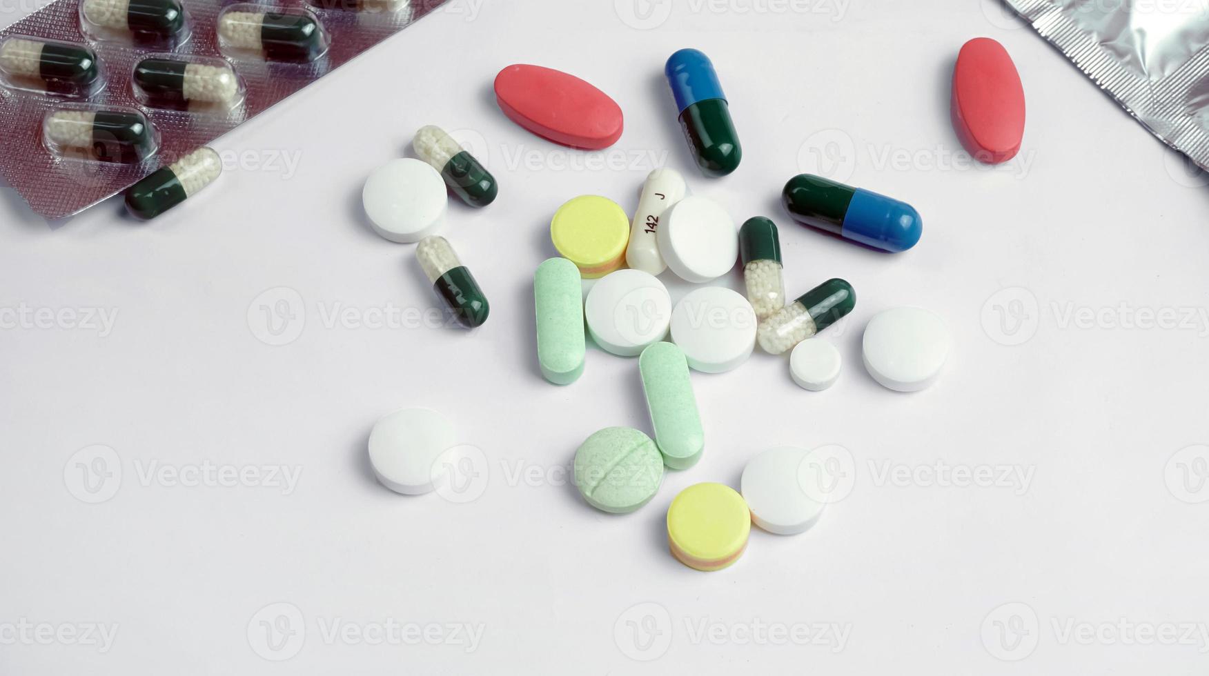 Multicolored pills and tablets on white background photo