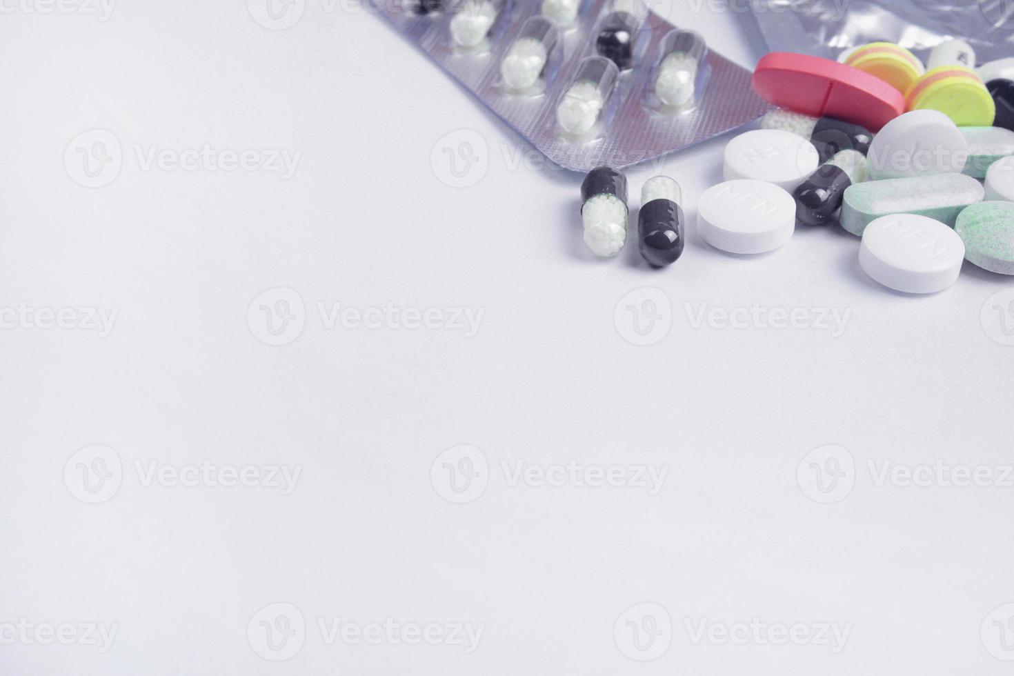 Multicolored pills and tablets on white background photo